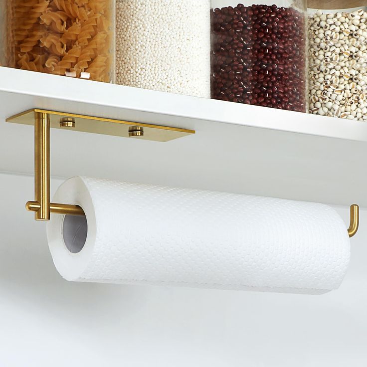 two rolls of toilet paper are hanging on the wall above a shelf with other items