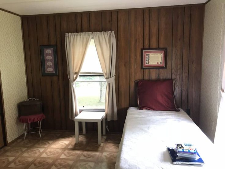 a small bed in a room with wooden paneling