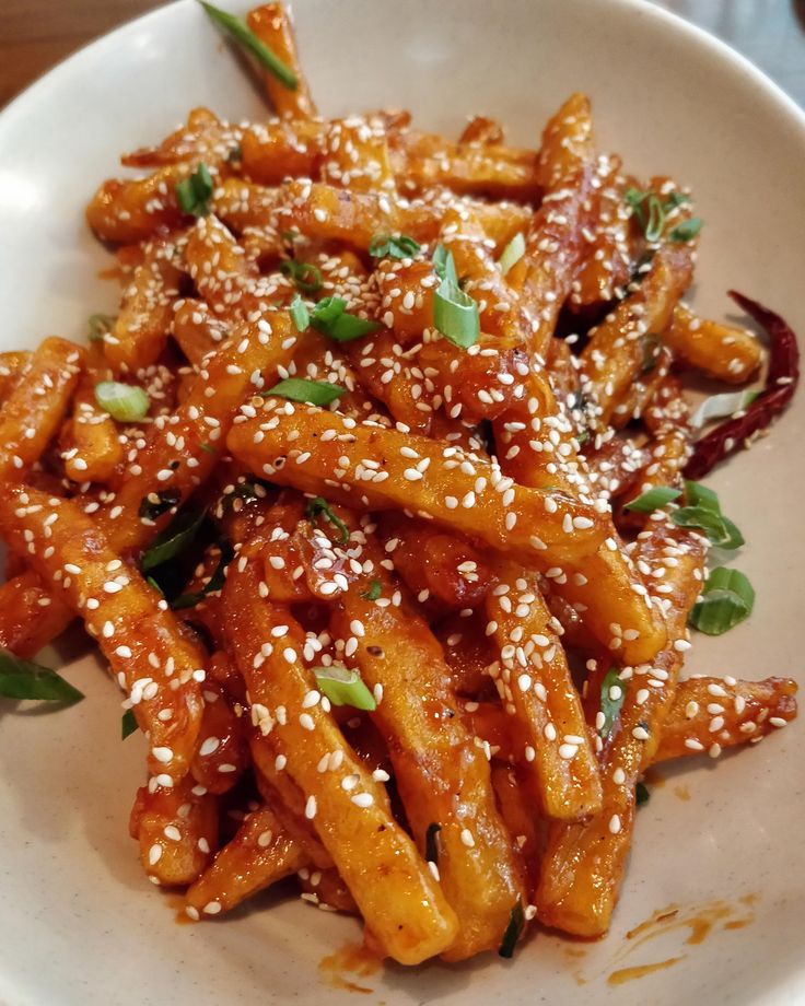 a white plate topped with sesame seed fries