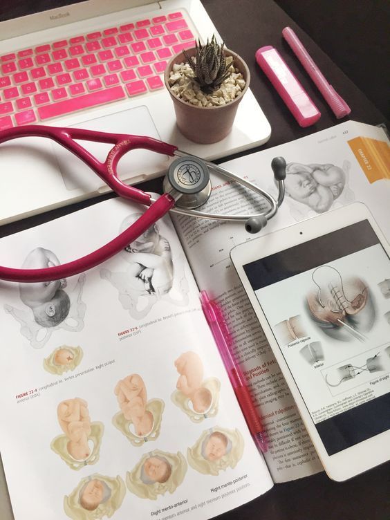 an open book with medical equipment on top of it next to a laptop and phone