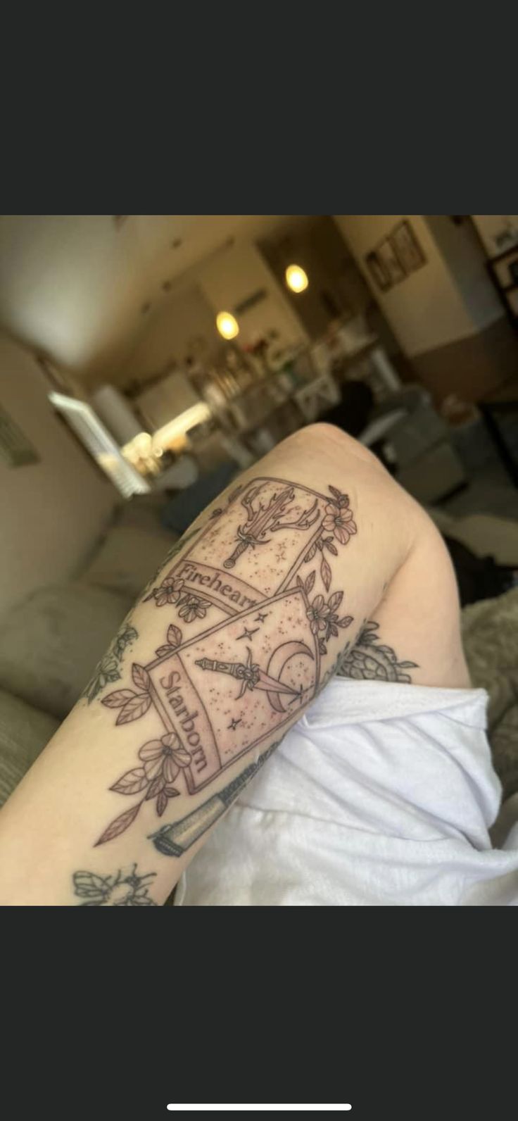 a person with a tattoo on their arm is laying down and looking at the camera