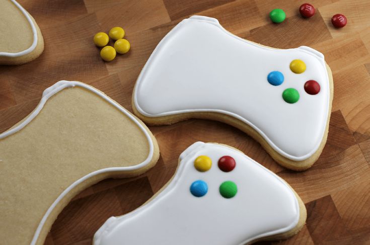 three decorated cookies sitting on top of a wooden table