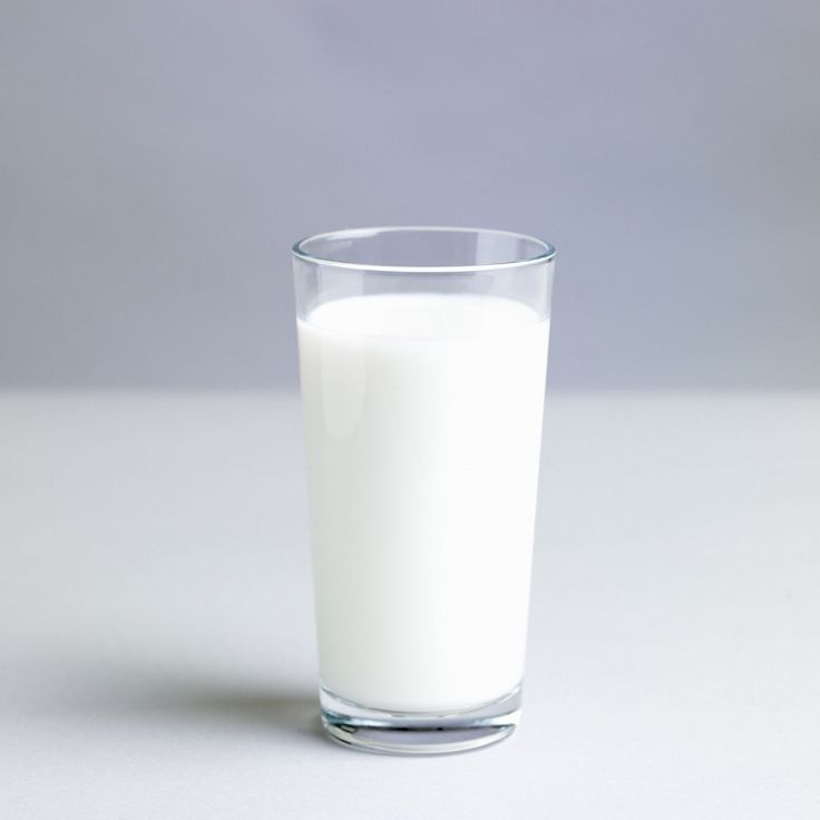 a glass filled with milk sitting on top of a table