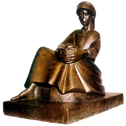 a bronze statue of a man sitting down