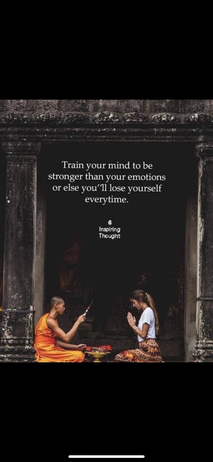 two women sitting in front of an old building with a quote on the wall above them