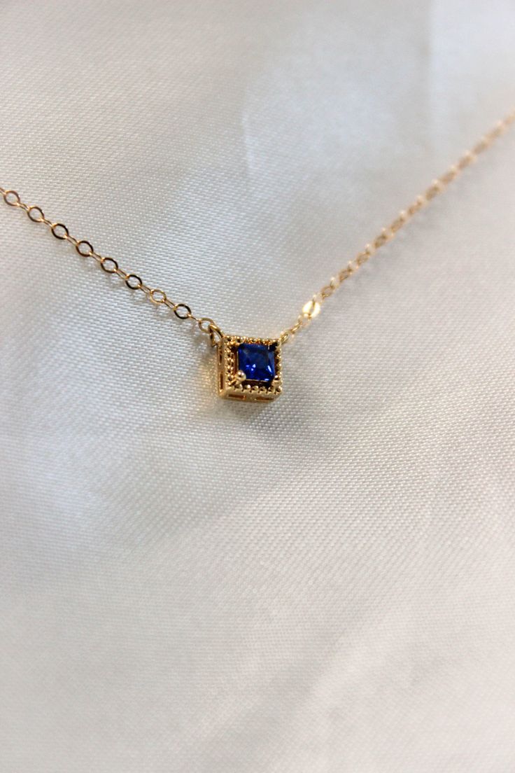 PRODUCT DESCRIPTION Chic and sophisticated, this Diane Necklace is inspired by the glamour of bygone eras. This opulent piece is crafted in 18k Gold-plated or 14k Gold-filled with metal and features a blue square-cut cubic zirconia pendant. Effortlessly elegant and pairs beautifully with day and evening ensembles. You are fine to shower in our gold-filled jewelry. Get it wet, wear it for life! A Dainty yet Elegant Necklace Water and Tarnish Resistant 14k Gold-filled with jeweler's brass (at leas Gold Plated Rectangular Fine Jewelry, Gold Jewelry With Rectangular Stone For Formal Occasions, Gold Jewelry With Rectangular Stone For Formal Events, Yellow Gold Sapphire Necklaces For Wedding, Elegant Sapphire Necklace With Diamond Cut, Rectangular Gold Plated Fine Jewelry, Formal Gold Jewelry With Rectangular Stone, Formal Birthstone Necklace Fine Jewelry, Elegant Rectangular Pendant Jewelry For Anniversary