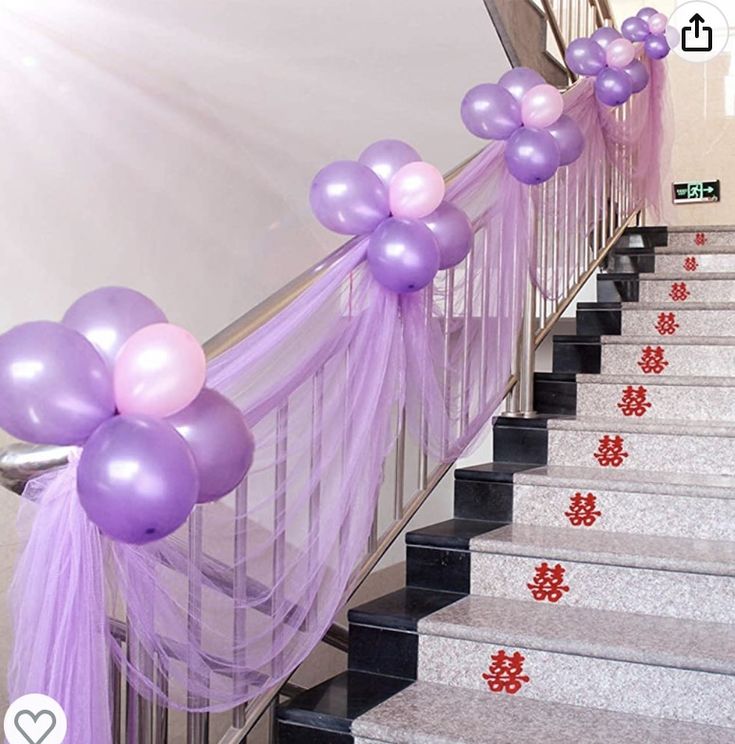 purple and pink balloons are tied to the banisters on this staircase for a party