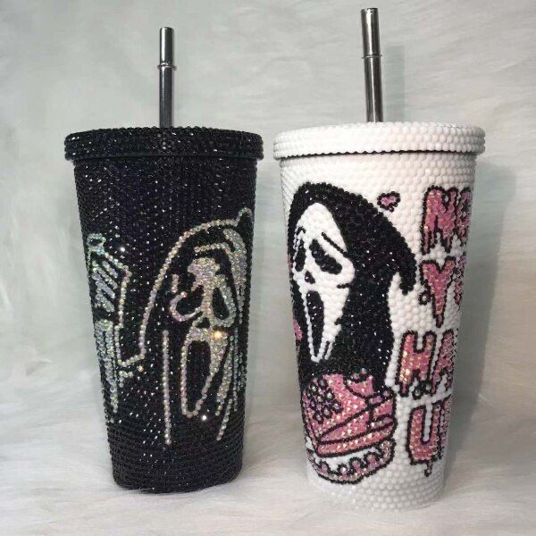 two black and white cups with designs on them, one has a skull in the middle