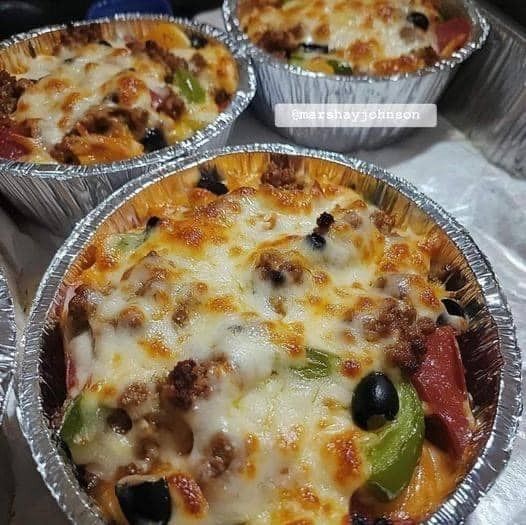 three pizza pies sitting on top of tin foil pans covered in cheese and toppings