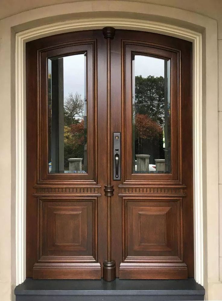 a pair of double doors with sidelights and glass panels on the front entry door