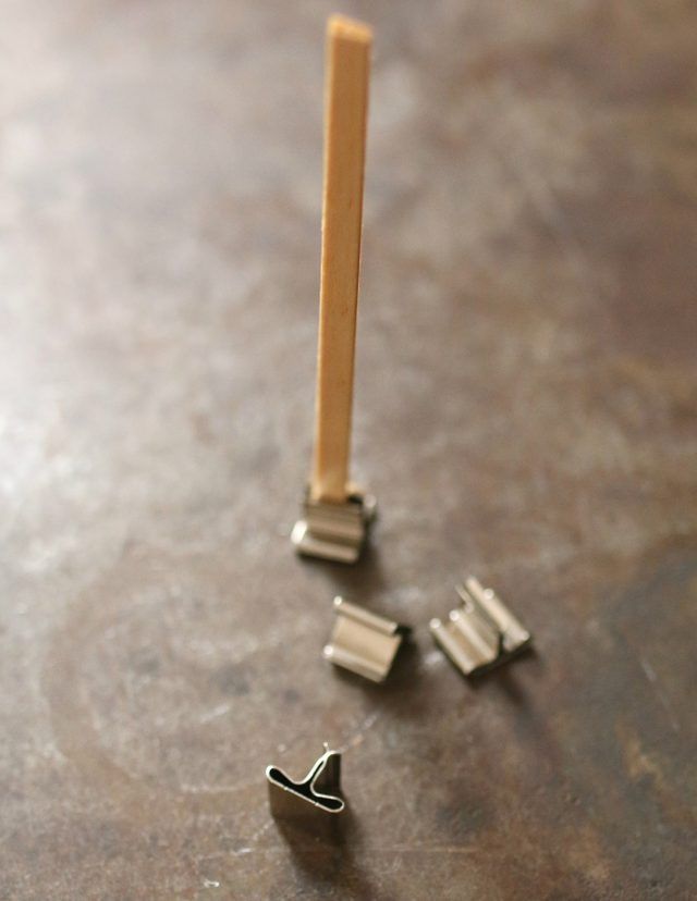 three pieces of metal sitting on top of a wooden table next to a toothbrush