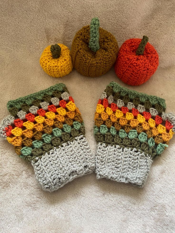 three knitted pumpkins and two crocheted mitts