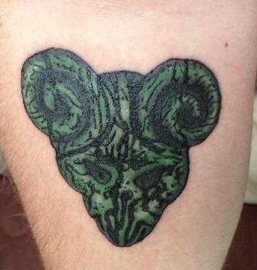 a man's leg with a tattoo on it that has an animal head in the shape of a heart