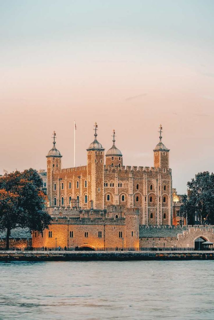 the tower of london is lit up at dusk