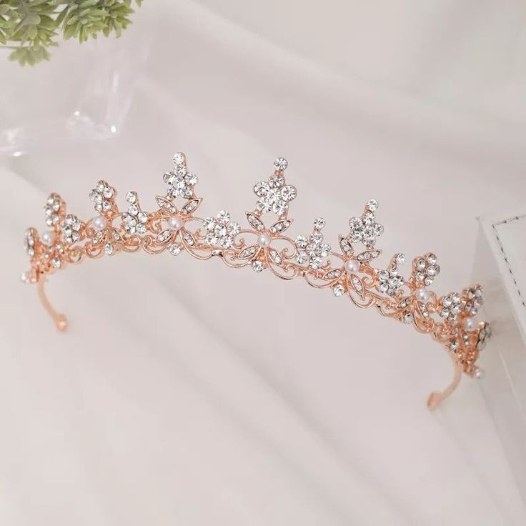 a tiara is sitting on a table next to a vase with flowers in it