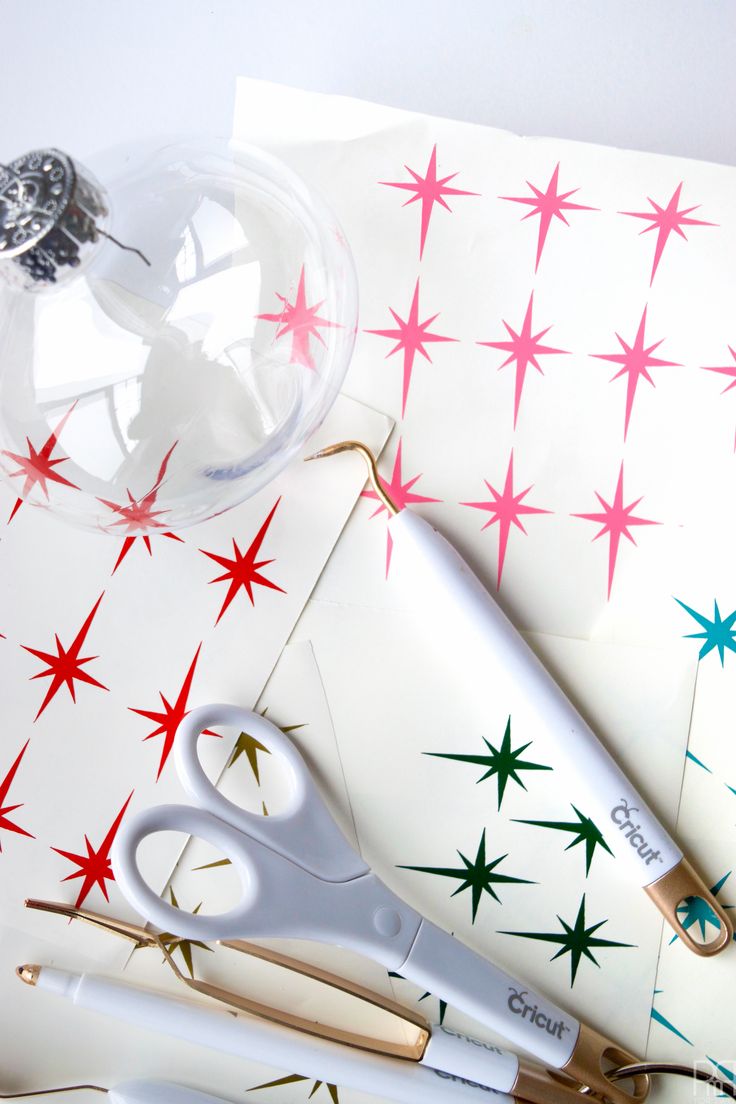 scissors and other crafting supplies sitting on top of a white paper with red and green stars