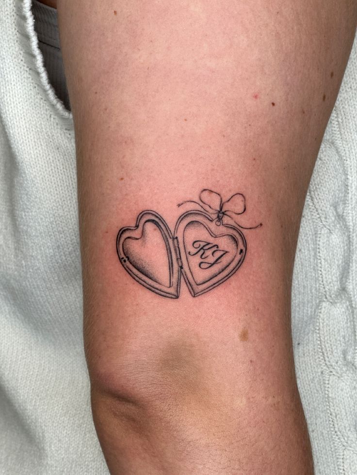 a woman's arm with two hearts and the word love tattooed on her left side