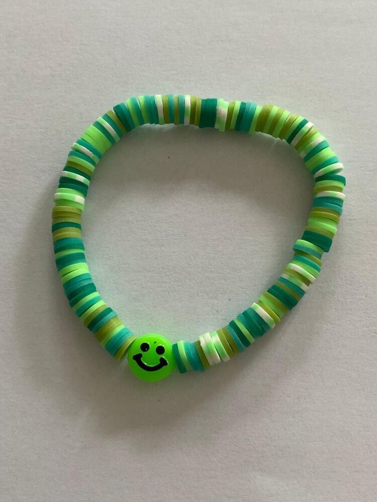 Colourful bracelet in shades of green with a smiley face Cute Green Round Bead Jewelry, Casual Green Round Jewelry, Fun Green Stretch Bracelet For Friendship, Green Bangle Friendship Bracelets, Playful Green Beaded Bracelet As A Gift, Trendy Green Beaded Bracelets For Friendship, Handmade Green Beaded Round Bracelets, Playful Green Beaded Friendship Bracelets, Fun Green Beaded Stretch Bracelet