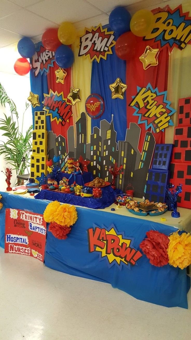 a table with decorations and balloons on it in a room decorated for a birthday party