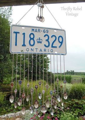 a sign hanging from the side of a building with lots of spoons attached to it