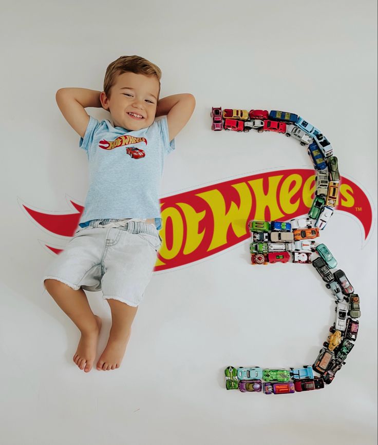 a young boy laying on top of a skateboard with his arms behind his head