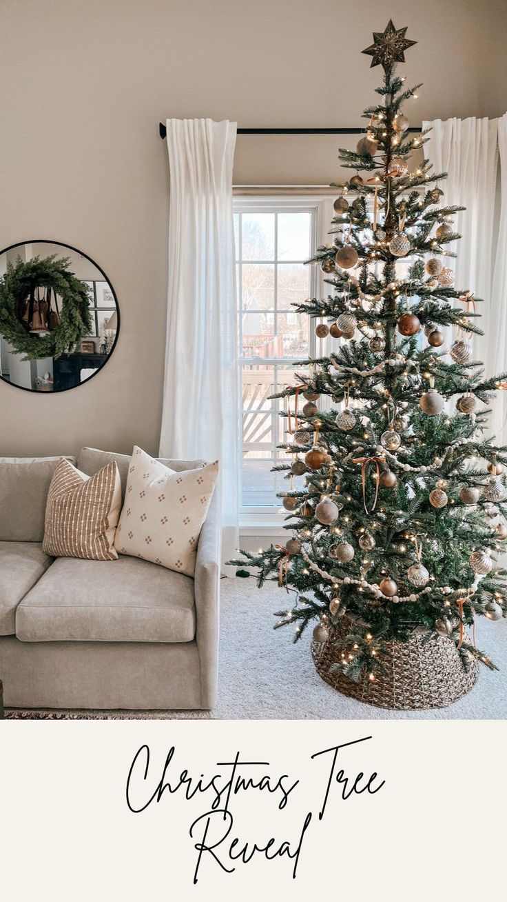 a christmas tree in a living room next to a couch and window with the words christmas tree reveal