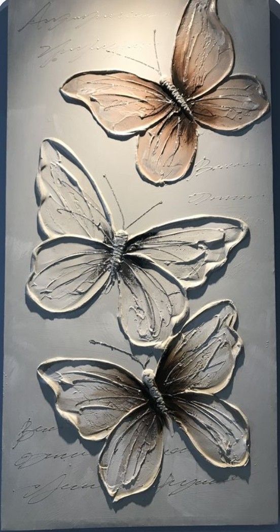 three butterflies are shown on a metal plaque