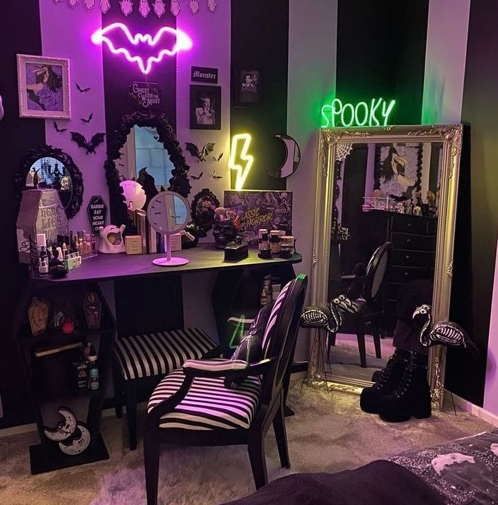 a bedroom decorated in black and purple with neon lights on the wall, mirror, desk and chair