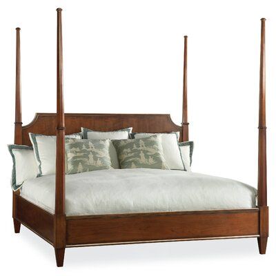 a bed with four posts and pillows on top of it, against a white background