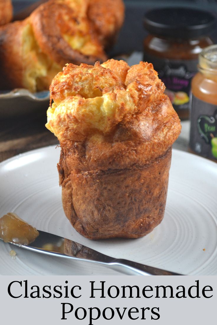 a close up of a muffin on a plate with the words classic homemade popovers