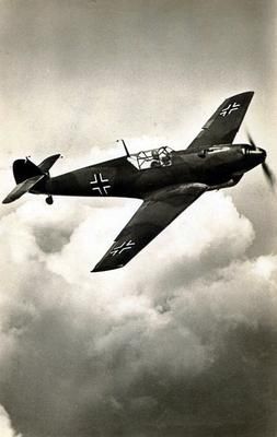 an old airplane flying in the sky with clouds around it and two men on top of it