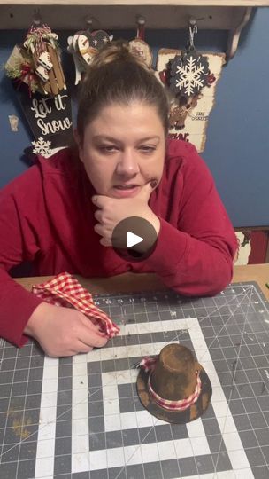 a woman sitting at a table with a hat on top of it and making a face