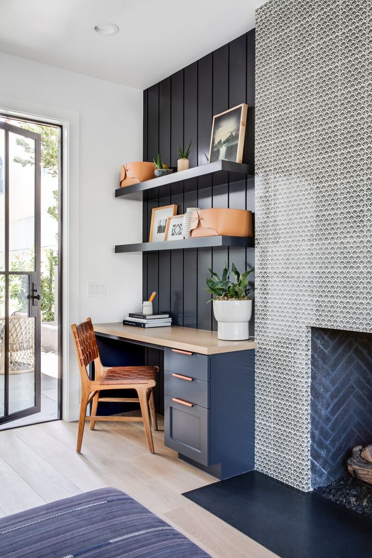 a room with a fireplace, desk and shelves on the wall next to an open door