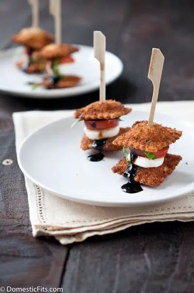 small appetizers with toothpicks in them on white plates