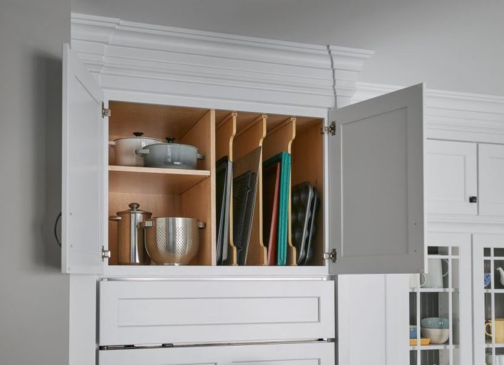 an open cabinet in a kitchen filled with cooking utensils