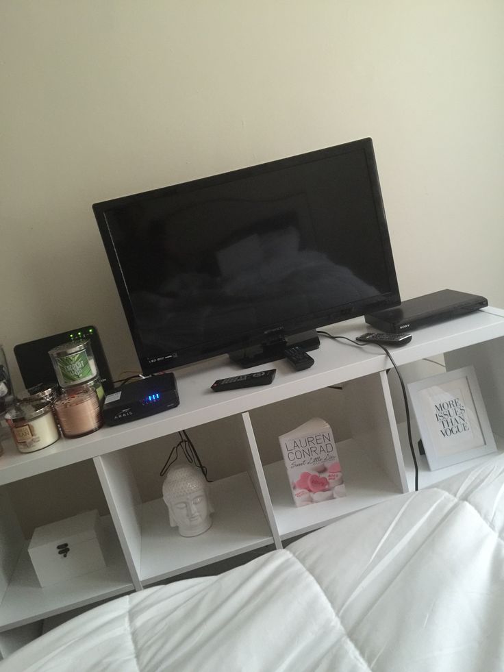 a flat screen tv sitting on top of a white shelf