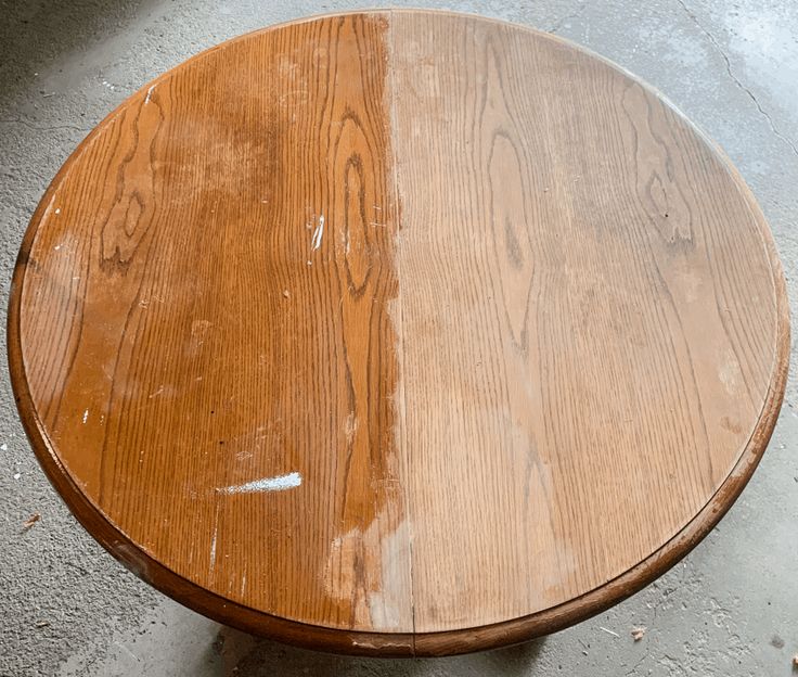 a wooden table that has been stained brown and is sitting on the concrete floor next to a window