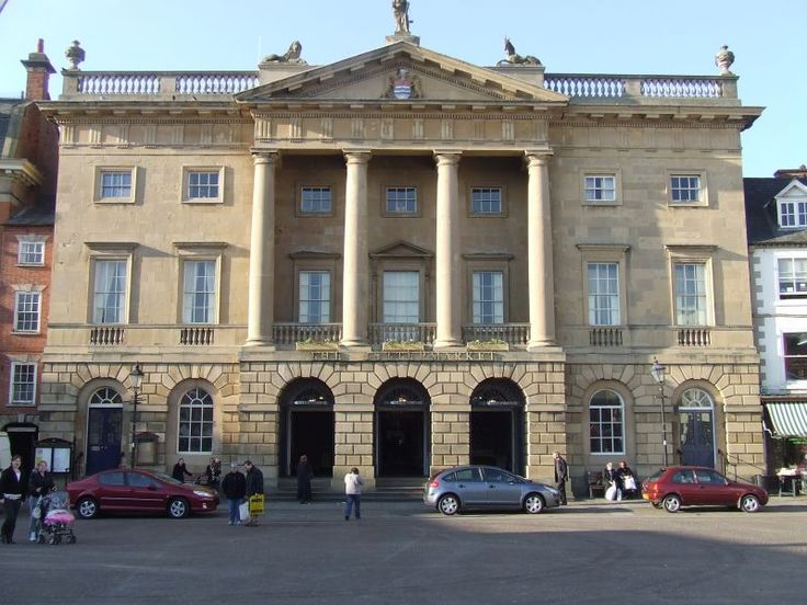 an old building with many cars parked in front