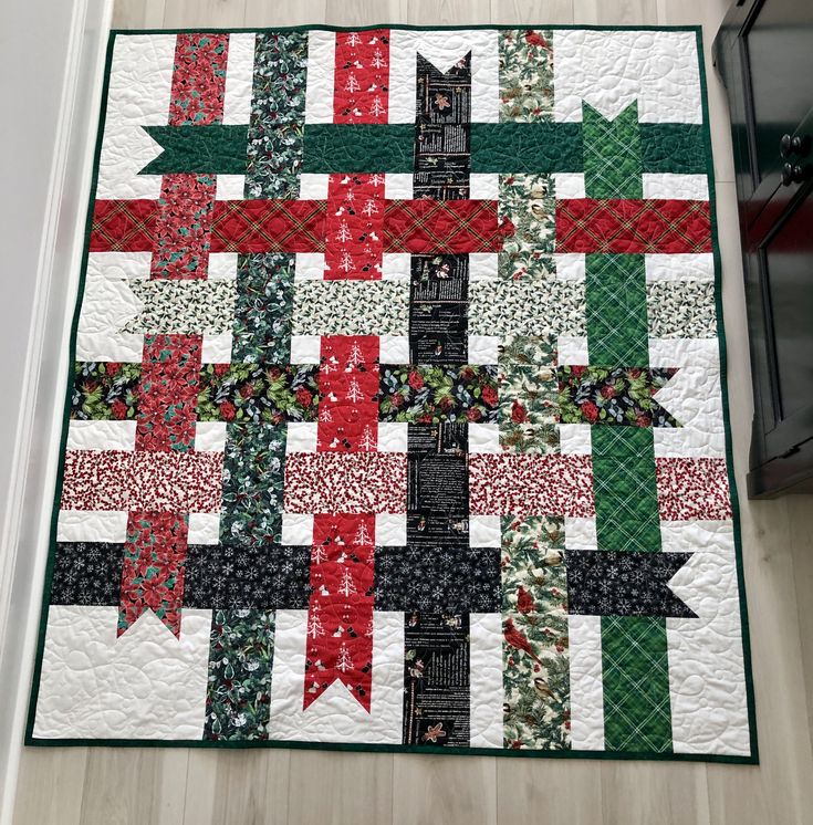 a quilted christmas tree with red, green and white ribbons on it's sides