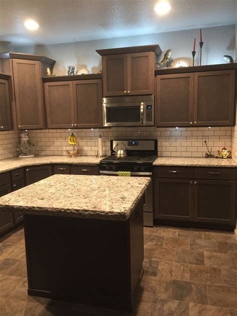 a kitchen with granite counter tops and brown cabinets