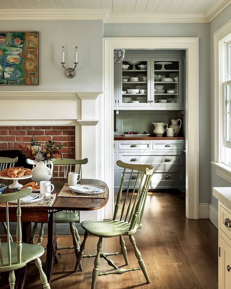 a dining room table and chairs in front of a fire place with a brick oven