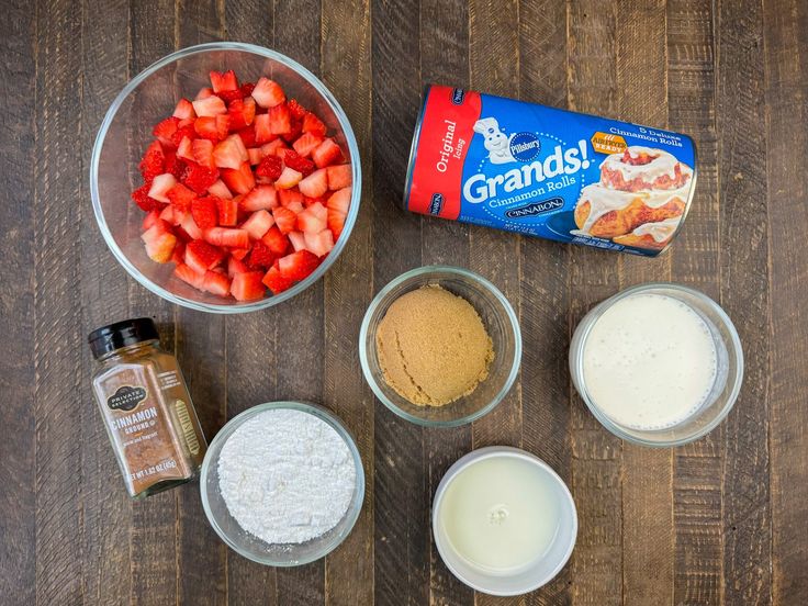 ingredients to make strawberry shortcakes laid out on a wooden table