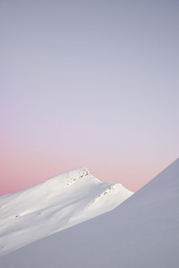 a person on skis is going down a snowy hill at sunset or dawn in the mountains