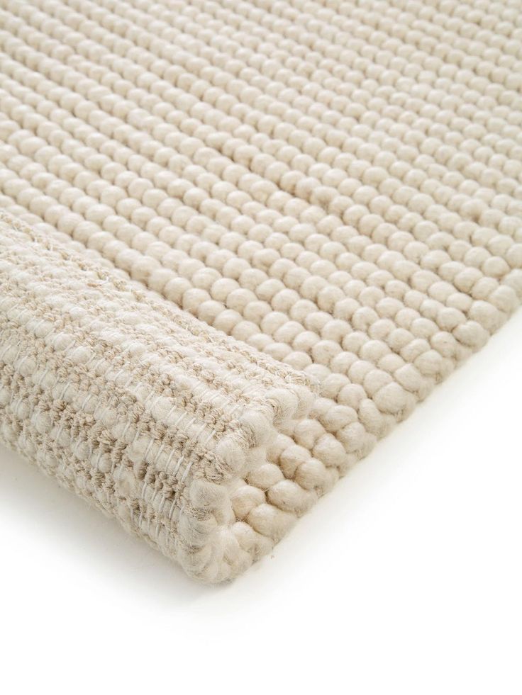 a white rug on top of a white floor with an area rug in the middle