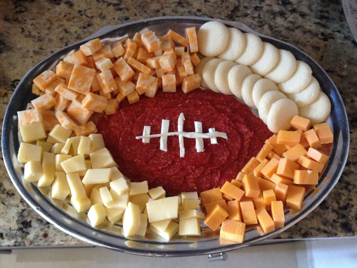 a football shaped platter with cheese and crackers