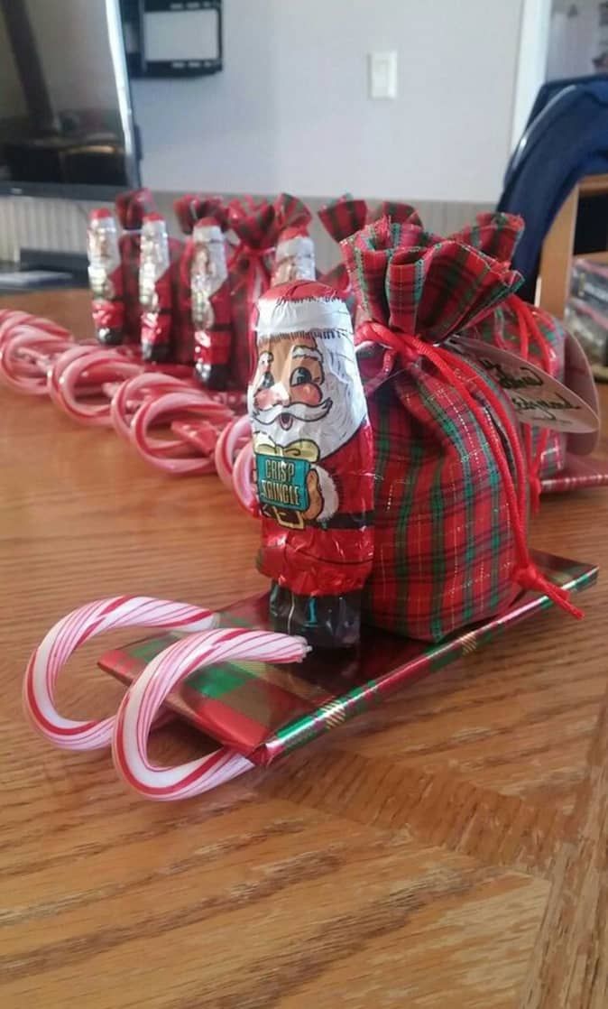 a wooden table topped with candy canes and santa clause on top of sled