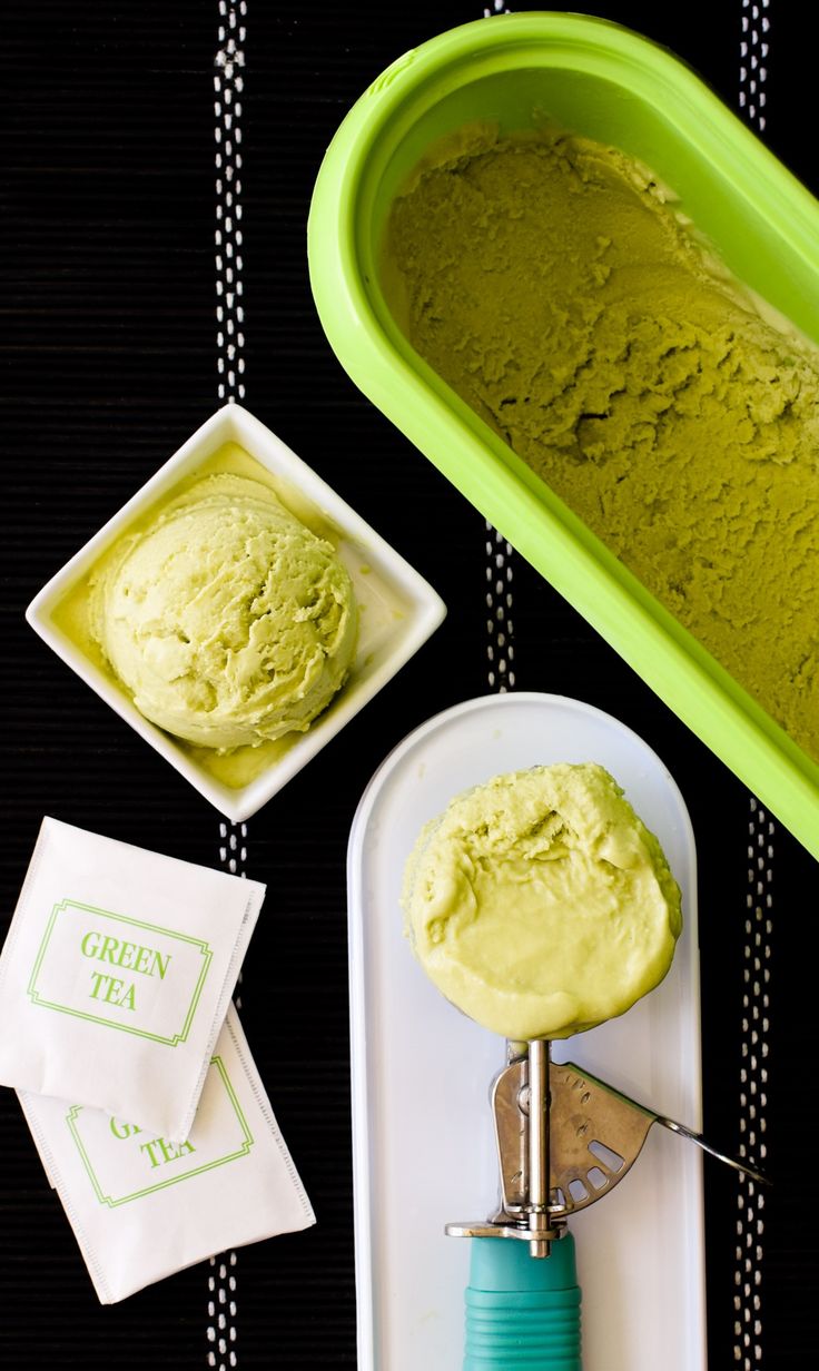 green tea ice cream in a bowl and scooper next to it on a tray