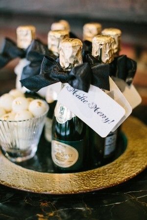 a bottle of champagne and some cupcakes on a plate with a name tag