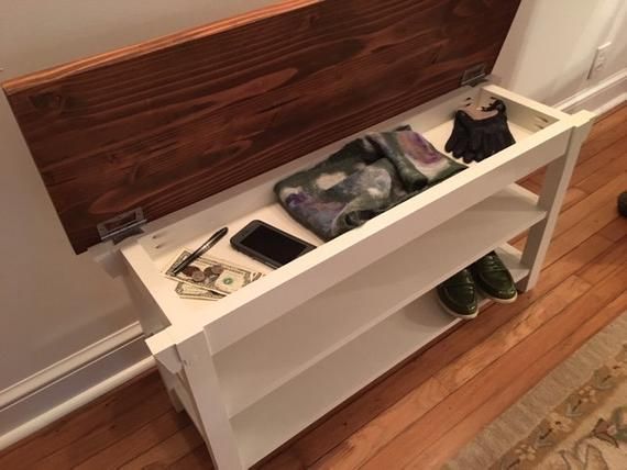 a shelf with shoes, cell phone and wallets on it next to a door