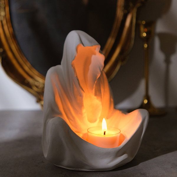 a candle that is sitting in front of a mirror